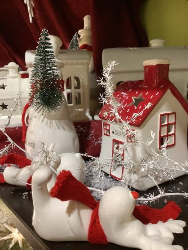 Weihnachtliche Dekoration mit Häuschen, Figuren und Schneeflocken.