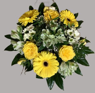 Ein bunter Blumenstrauß mit gelben Gerbera, Rosen und weißen Blüten.