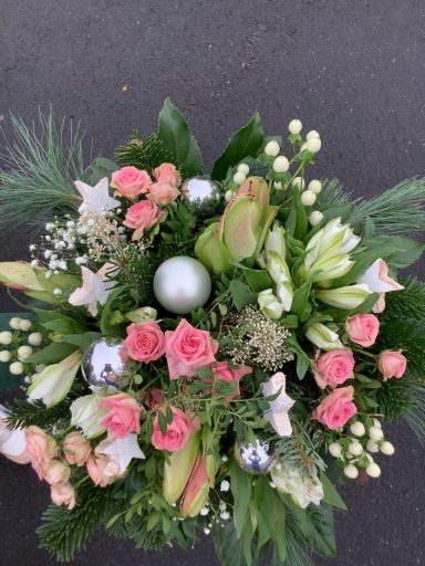 Bunte Blumenauswahl mit Rosen, Lilien und Grünpflanzen, ergänzt durch eine silberne Kugel.
